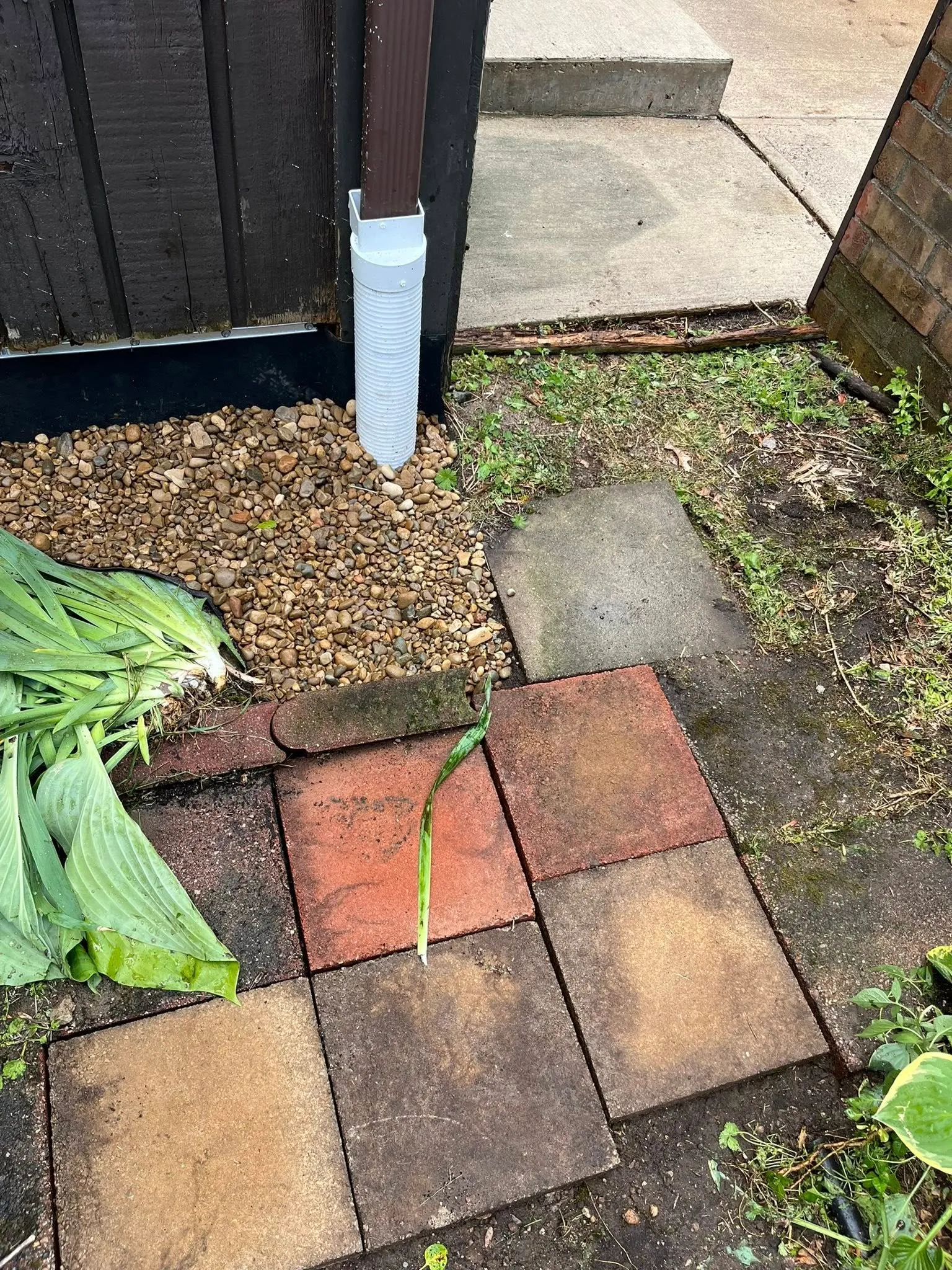 Downspout routed underground to carry roof water away from the foundation