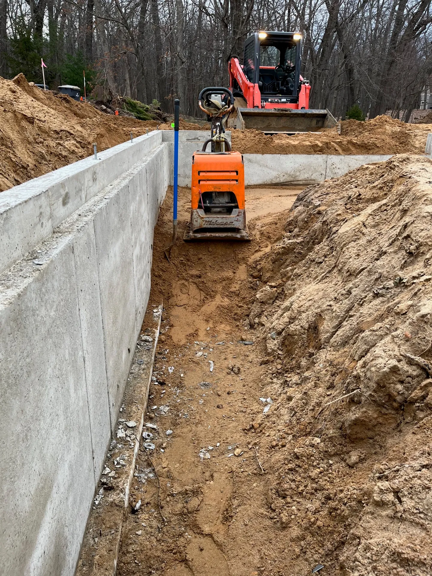 Excavator and skid steer opening a trench for a new utility line in Kalamazoo